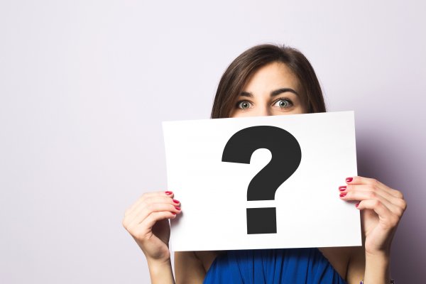 woman holding sign with question mark truecredit credit monitoring service